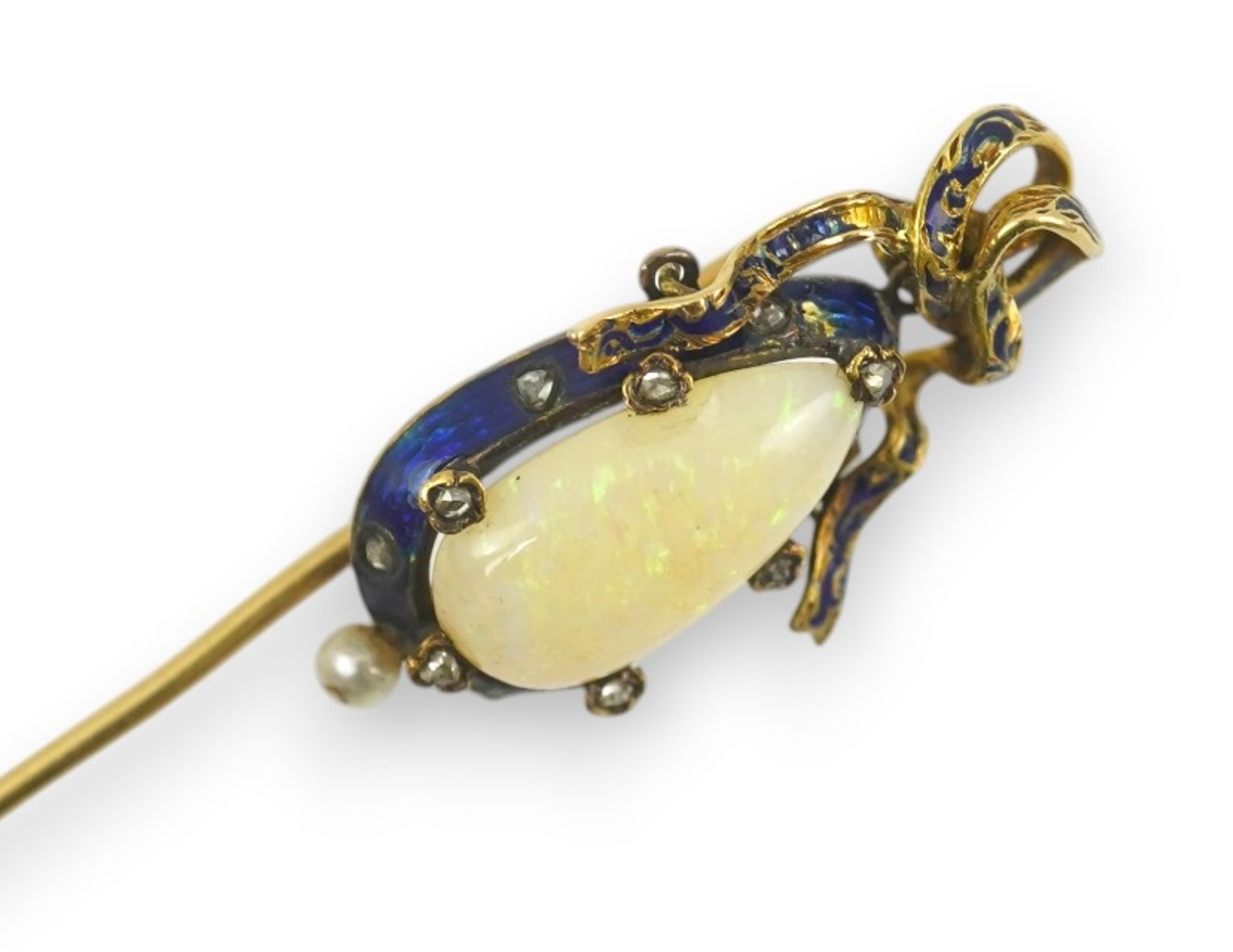 A late Victorian gold, white opal, seed pearl diamond chip and blue enamel set stick pin